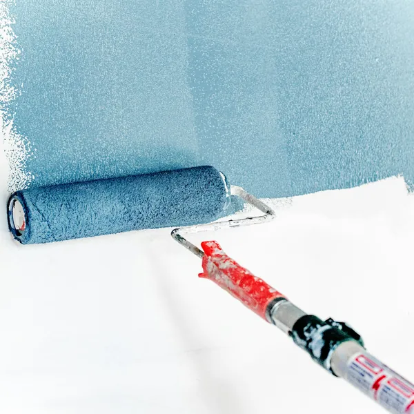 Maler streicht eine Wand mit der Rolle